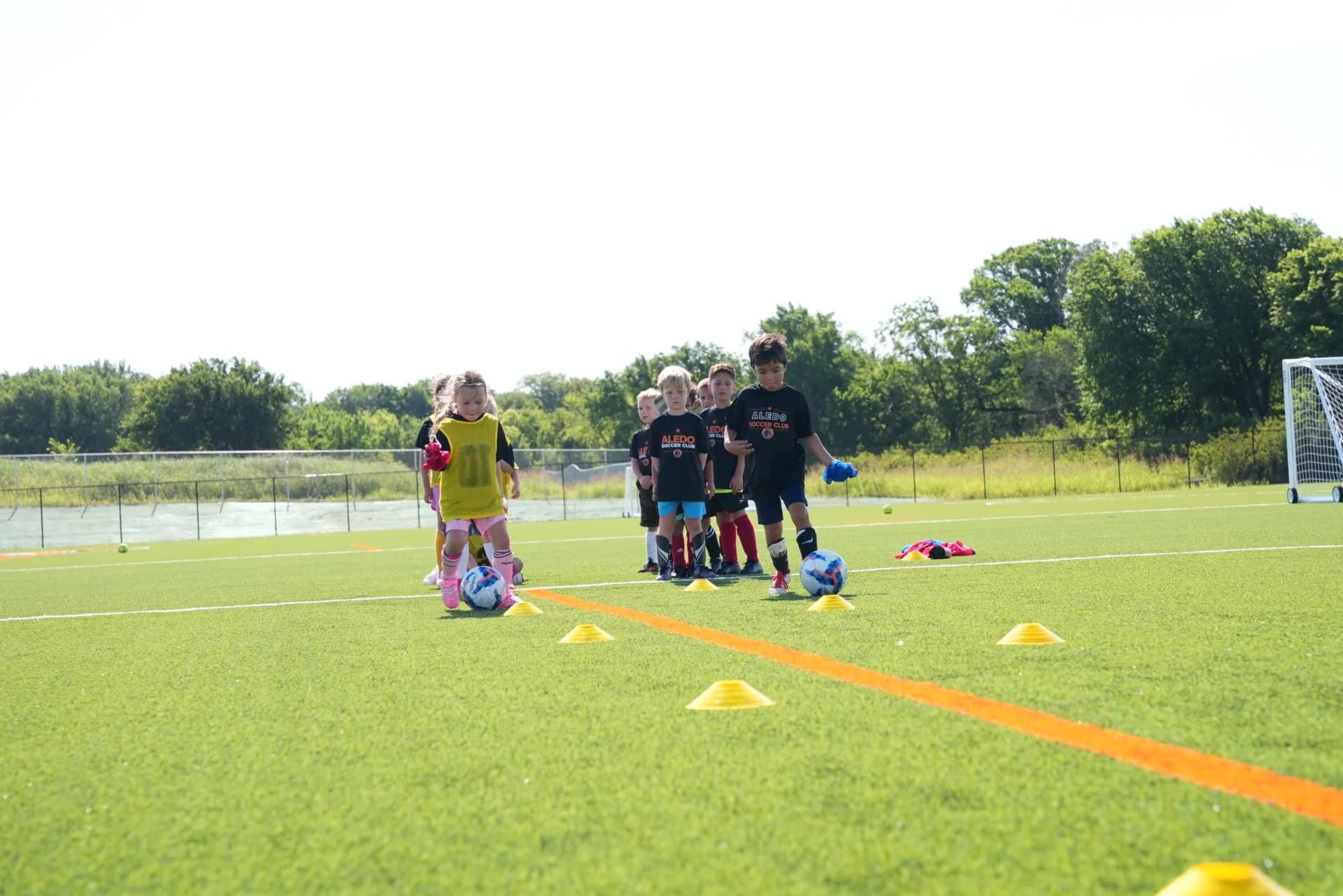 Young players working through a cone dribbling drill at The Stable