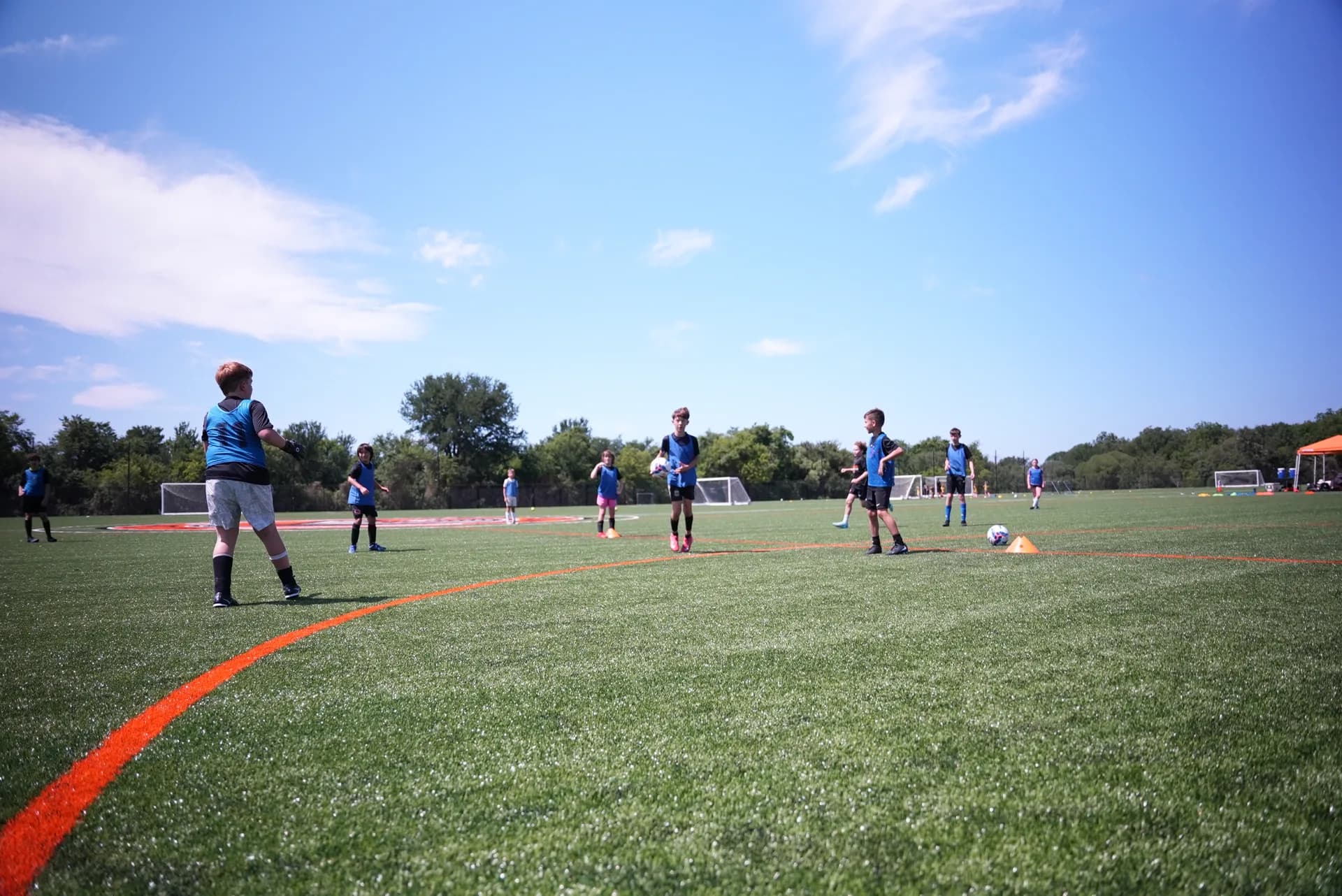 Youth game in progress on The Stable's turf under blue skies