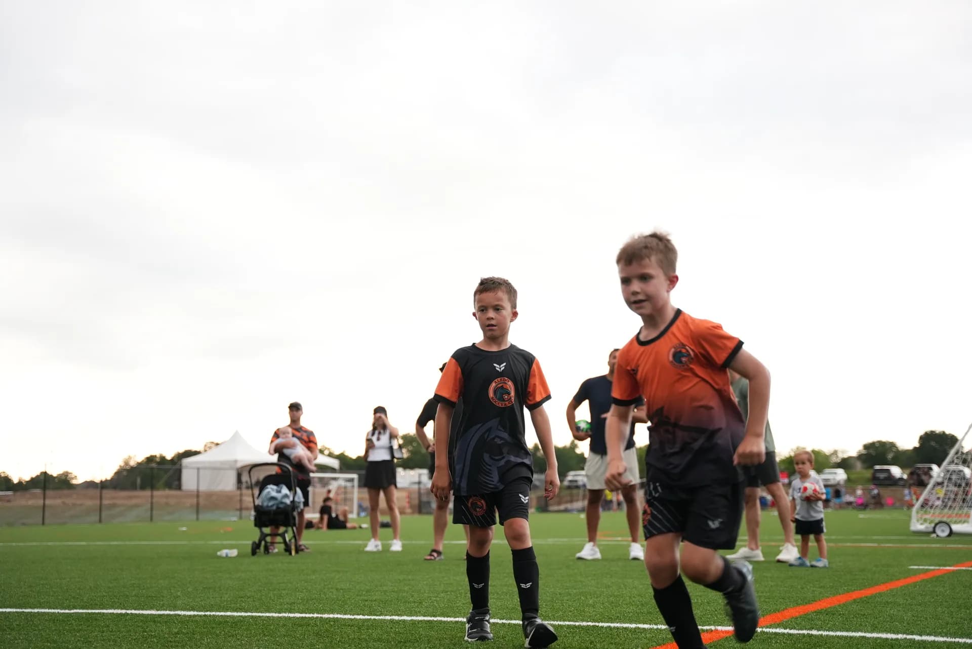 Aledo Soccer Club players in kit running drills at The Stable's grand opening